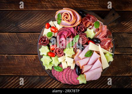 Tavole colorate di salumi e scatole di verdure, carne e formaggio. Assortimento di stuzzichini o antipasti gustosi. Vista dall'alto. Copia spazio Foto Stock