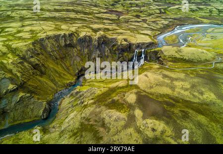 Vista aerea della cascata Fagrifoss circondata dal muschio verde, regione di Lakagígar, Sudurland, Islanda Foto Stock