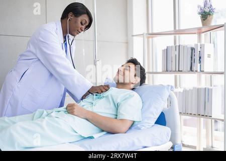 Medico africano visita mattutina paziente utilizzando stetoscopio controllo respiro polmonare e polso cardiaco maschio in ospedale Foto Stock