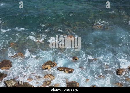 Schiuma marina sotto alte scogliere erose della costa settentrionale di Gran Canaria, zona di Galdar Foto Stock