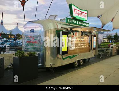 Caravan per caffè e ciambelle Krispy Kreme in stile Airstream Rocket food alla luce della sera Ashford Design Outlet Ashford Kent Inghilterra Regno Unito Foto Stock