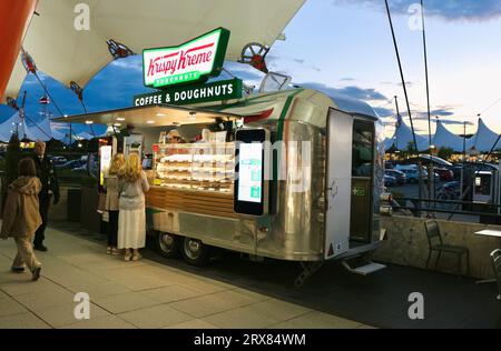 Persone al Krispy Kreme Coffee & Donuts Airstream in stile Rocket food Caravan alla luce della sera Ashford Design Outlet Ashford Kent Inghilterra Regno Unito Foto Stock