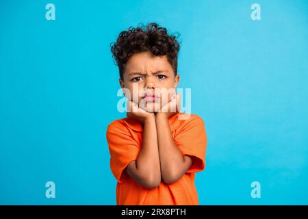 Foto di un ragazzino insoddisfatto che si sente arrabbiato isolato su sfondo blu Foto Stock