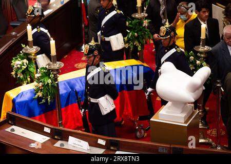 Bogotà, Colombia. 23 settembre 2023. La gente passa dietro la bara di Fernando Botero mentre il defunto artista colombiano si trova all'interno del Congresso Nazionale, dove la sua scultura "la colomba della pace" è collocata accanto alla bara durante la sua veglia a Bogotà, in Colombia, il 22 settembre 2023. Crediti: Long Visual Press/Alamy Live News Foto Stock