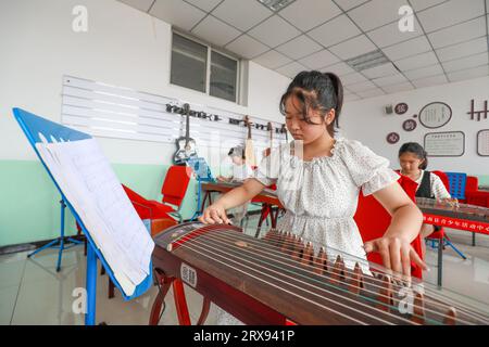 Contea di Luannan, Cina - 26 luglio 2022: I bambini stanno imparando a giocare al guzheng in classe. Foto Stock
