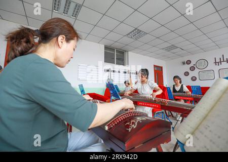 Contea di Luannan, Cina - 26 luglio 2022: I bambini stanno imparando a giocare al guzheng in classe. Foto Stock
