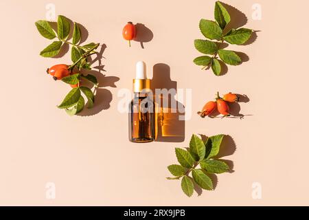 Flacone cosmetico con una pipetta con un rimedio naturale o siero a base di olio di rosa per la cura del viso e della pelle dei peli. Cure organiche Foto Stock