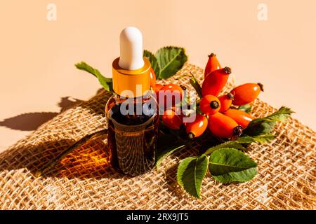 Flacone cosmetico con pipetta con un rimedio naturale a base di olio di semi di rosa per la cura della pelle stanca, sbiadita e secca. Vitamine Foto Stock