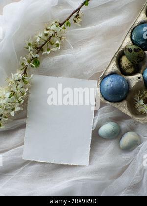 Uova di pasqua dipinte di blu. Uova di Pasqua tinte con effetto pietra marmorea colore azzurro su fondo tovaglia bianco con fiore di ciliegio. Uova backgrou Foto Stock