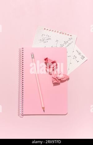 Su sfondo rosa, materiale scolastico rosa, calcolatrice, cheat sheets. Foto di alta qualità Foto Stock