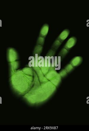 La stampa di una palma da uomo è colorata di un verde velenoso, di colore radioattivo, con un effetto sfocato, su sfondo nero Foto Stock