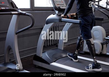 giovane persona disabile che fa un efficiente allenamento aerobico. concentrarsi sulle protesi delle gambe Foto Stock