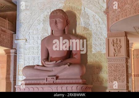 Statua isolata del dio giaino in pietra rossa in meditazione da diverse angolazioni è scattata presso Shri Digamber Jain Gyanoday Tirth Kshetra, Nareli Jain ma Foto Stock