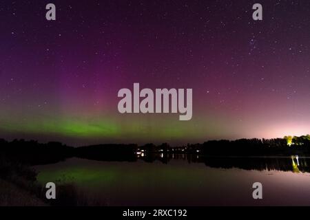Immagine notturna di un'imponente e vibrante aurora boreale verde multicolore, Aurora Polaris conosciuta anche come l'aurora boreale nel cielo notturno sopra un lago, L. Foto Stock