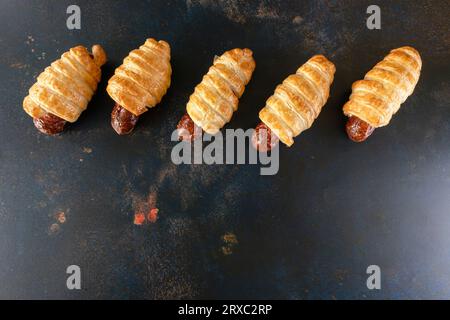 I mini panini di salsiccia sono presentati come uno spuntino in uno sfondo rustico. Foto Stock