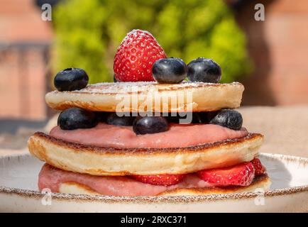 A colazione potrai gustare pancake all'americana conditi con frutti di bosco freschi e salse a tua scelta. Foto Stock