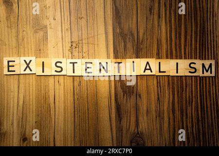 Parola di concetto esistenzialista in lettere di legno su sfondo di legno scuro Foto Stock