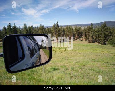 Vista dallo specchietto retrovisore dal punto di vista di un passeggero che si affaccia sul paesaggio della British Columbia, Canada. Foto Stock