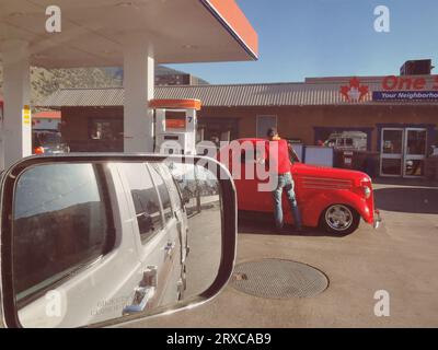British Columbia, Canada - 4 giugno 2023: Vista dallo specchio laterale che guarda un veicolo in una stazione di servizio vicino a Middle Bench Road, Keremeos. Foto Stock