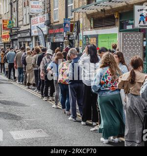 I clienti della domenica presto fanno la fila per comprare i bagel nei famosi negozi di Beigel a Brick Lane, all'estremità orientale di Londra Foto Stock