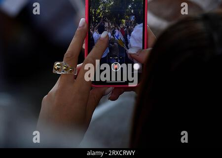 Marsiglia, Francia. 23 settembre 2023. Una donna filma l'evento con il suo cellulare. Migliaia di persone sono venute a vedere Papa Francesco passeggiare nel suo "Papamobile" in Avenue du Prado, hanno partecipato all'alta massa su schermi giganti allo stadio Vélodrome. (Foto di Gerard bottino/SOPA Images/Sipa USA) credito: SIPA USA/Alamy Live News Foto Stock