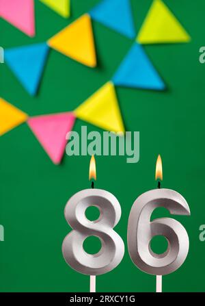 Cartolina di compleanno verticale con numero di candela 86 - sfondo verde con pennant Foto Stock