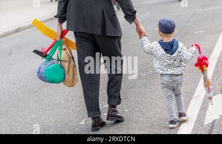 Amburgo, Germania. 24 settembre 2023. Un uomo sta attraversando una strada con suo figlio per mano. Credito: Markus Scholz/dpa/Alamy Live News Foto Stock