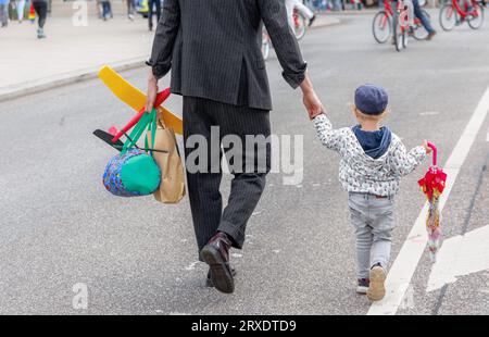 Amburgo, Germania. 24 settembre 2023. Un uomo sta attraversando una strada con suo figlio per mano. Credito: Markus Scholz/dpa/Alamy Live News Foto Stock
