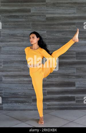 Uccello del paradiso o Svarga Dvijasana yoga con donna ucraina che lo fa al chiuso Foto Stock