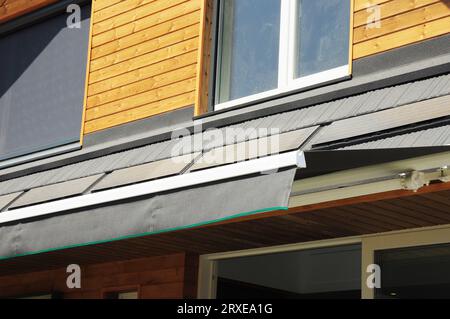 Primo piano sui pannelli solari e sul sistema automatico di tettoia scorrevole del tetto apribile, tenda da da patio per l'ombrellone di una casa. Foto Stock