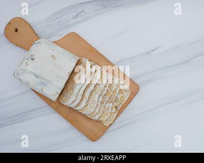 vista dall'alto del tempeh grezzo a fette su tagliere di legno Foto Stock