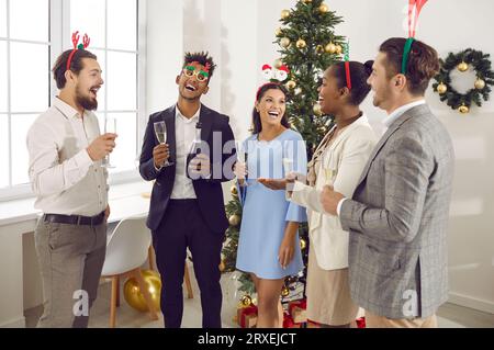 I colleghi allegri fanno brindisi durante la festa aziendale di Capodanno in ufficio. Foto Stock