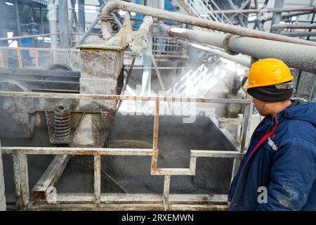 Luannan, Cina - 13 febbraio 2023: I lavoratori controllano le attrezzature di trazione per il trasporto di nuovi materiali da costruzione - pannelli silicati di calcio - da autoclavi Foto Stock