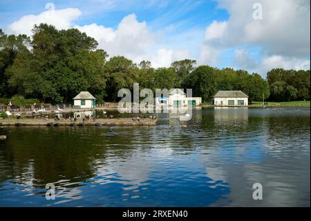 Riflessi nel lago di Stanley Park, molo nord di Blackpool al tramonto Foto Stock