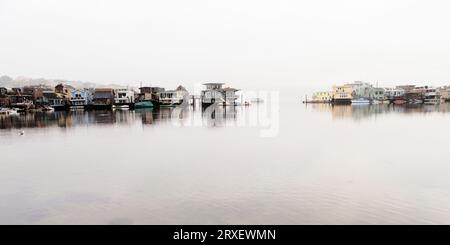 Case galleggianti al mattino all'orizzonte nebbioso. Foto Stock