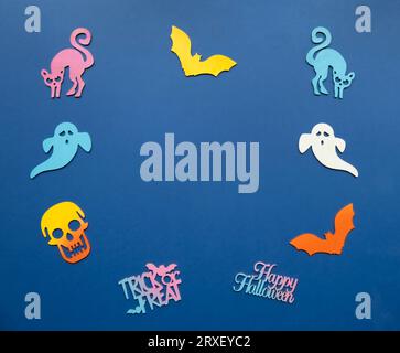 Ritagli pastello di halloween scattati dall'alto su sfondo blu. Foto Stock