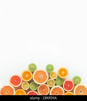 Concept estivo creativo composto da vari agrumi su sfondo bianco. Layout minimo. Piano, parte superiore della vista. Foto Stock