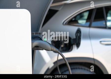 Primo piano di un'auto elettrica con un cavo. Foto Stock