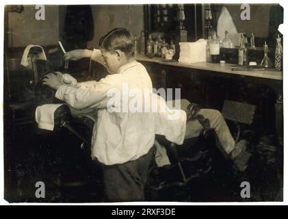 Lewis Hine: Frank De Natale, barbiere di 12 anni, Boston, 1917 Frank De Natale, barbiere di 12 anni. Adora e rasa i clienti nel negozio del padre, 416 Hanover Street, dopo la scuola e il sabato. Località: Boston, Massachusetts. Foto Stock