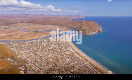 La vista aerea della panoramica baia del Mar del Giappone, del fiume e delle colline gialle autunnali del villaggio Moryak-Rybolov a Primorsky Krai in Russia. Foto Stock