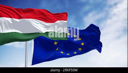 Le bandiere dell'Ungheria e dell'Unione europea sventolano insieme in una giornata limpida. L'Ungheria è diventata membro dell'Unione europea nel 2004. spia 3d Foto Stock