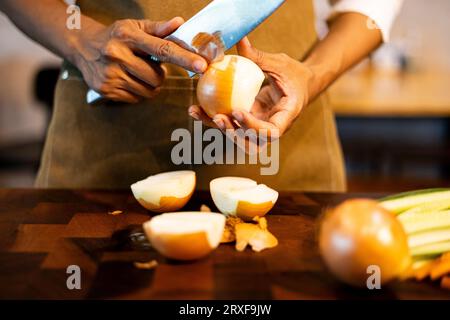 Pelare la cipolla, sfondi per pubblicità e sfondi in cibo e scene di cucina. Immagini reali nelle idee di decorazione. Foto Stock