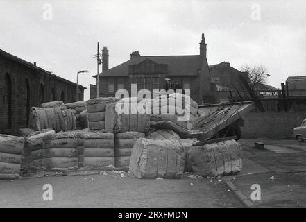 1960, storico, un grande carico di lana giacente in strada, caduto dal retro di un camion Bedford a Oldham, Inghilterra, Regno Unito. Foto Stock