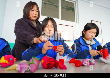 Luannan, Cina - 9 marzo 2023: Studentesse che fanno gourde di tessuto in classi di artigianato, Cina settentrionale Foto Stock