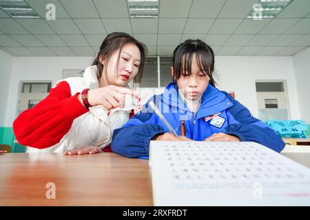 Luannan, Cina - 9 marzo 2023: Insegnante femminile guida gli studenti nella pratica della calligrafia, Cina settentrionale Foto Stock