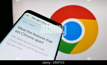 Telefono cellulare con sito Web del browser Web Google Chrome sullo schermo davanti al logo aziendale. Mettere a fuoco in alto a sinistra sul display del telefono. Foto Stock