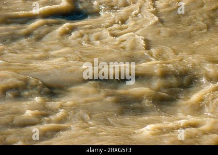 Acqua fangosa che scorre nel fiume dopo una tempesta di pioggia Foto Stock