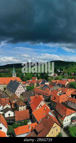 Vista aerea di Koenigsberg in Baviera. La città è circondata da colline e foreste. Il cielo è nuvoloso e scuro, a indicare una tempesta in avvicinamento. Foto Stock