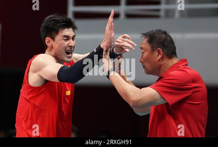 Hangzhou, provincia cinese di Zhejiang. 25 settembre 2023. Yu Yaochen (L) della Cina festeggia con il capo allenatore Wu Sheng durante la semifinale maschile di pallavolo tra Cina e Giappone ai 19 Giochi asiatici di Hangzhou, nella provincia dello Zhejiang, nella Cina orientale, il 25 settembre 2023. Crediti: Zhu Zheng/Xinhua/Alamy Live News Foto Stock