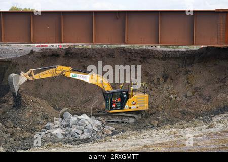 Gli appaltatori HS2 scavano un'area sotto una sezione appena sostituita del binario della diramazione Aylsebury-Princes Risborough che consentirà il passaggio della ferrovia ad alta velocità al di sotto, durante una visita del sito di costruzione di un nuovo ponte ferroviario ad Aylesbury, Buckinghamshire, che permetterà di costruire HS2 sotto la linea tra Aylesbury e Princes Risborough. Gli aggiornamenti ferroviari per HS2 hanno raggiunto la metà del percorso. Data immagine: Lunedì 25 settembre 2023. Foto Stock